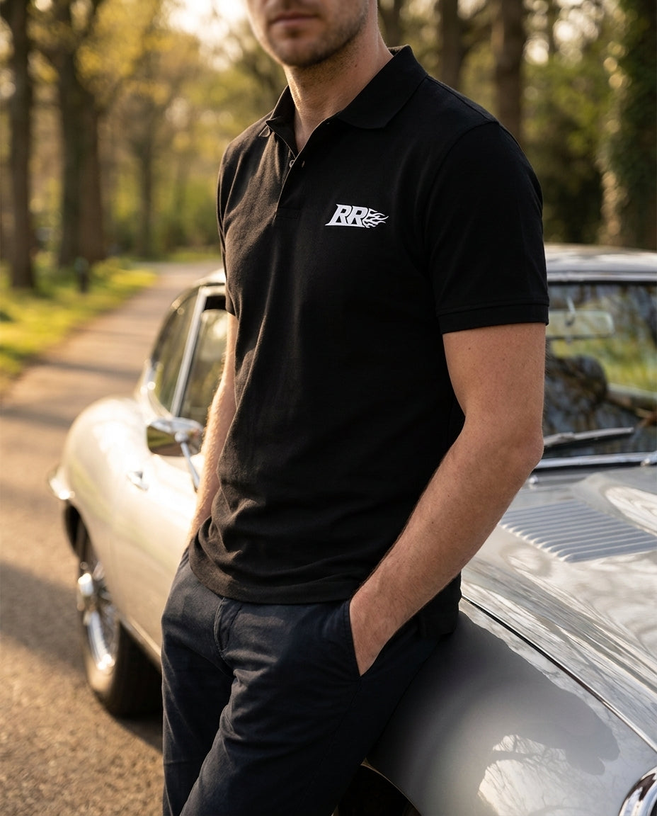 Rowdy Ridez Polo worn leaning on a vintage sports car at golden hour, collar down