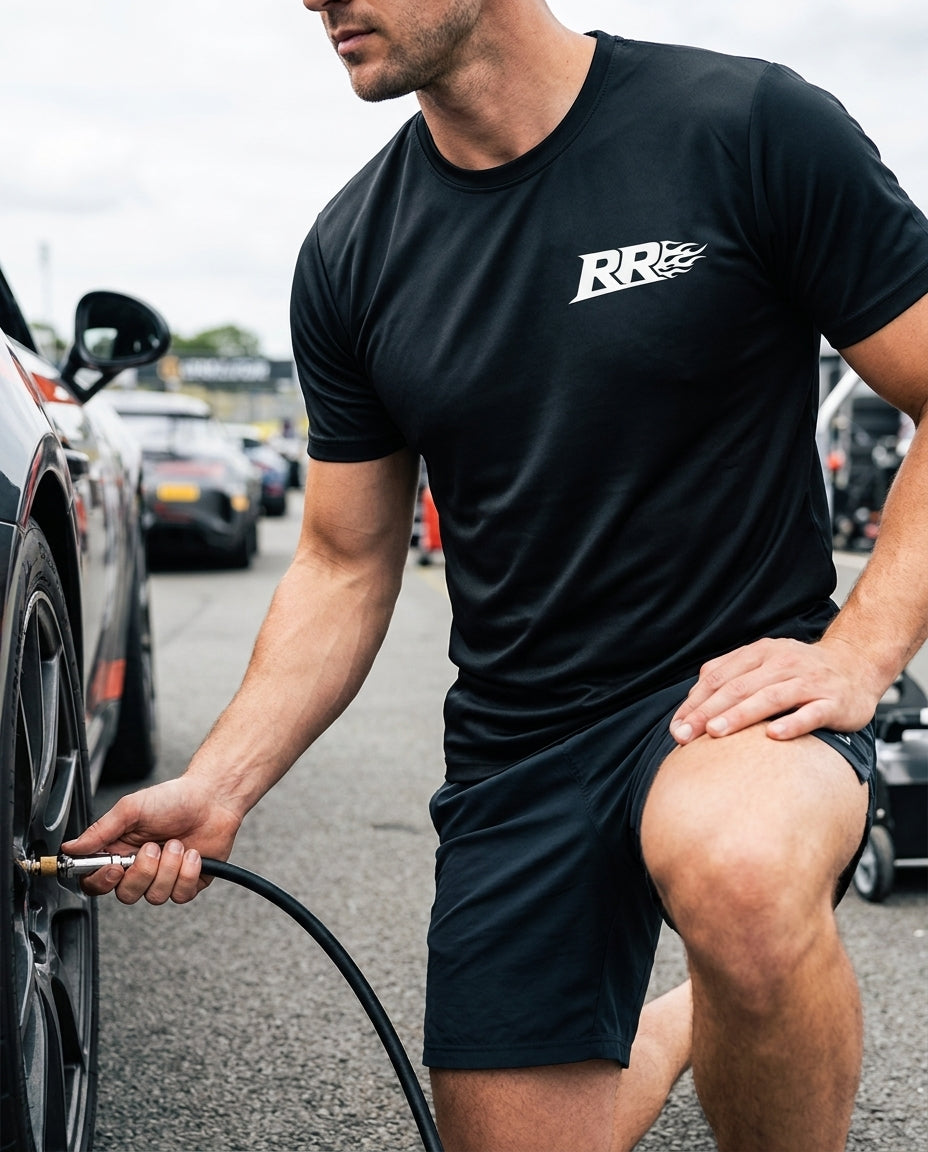 Rowdy Ridez Performance Tee worn at a track-day paddock checking tire pressure